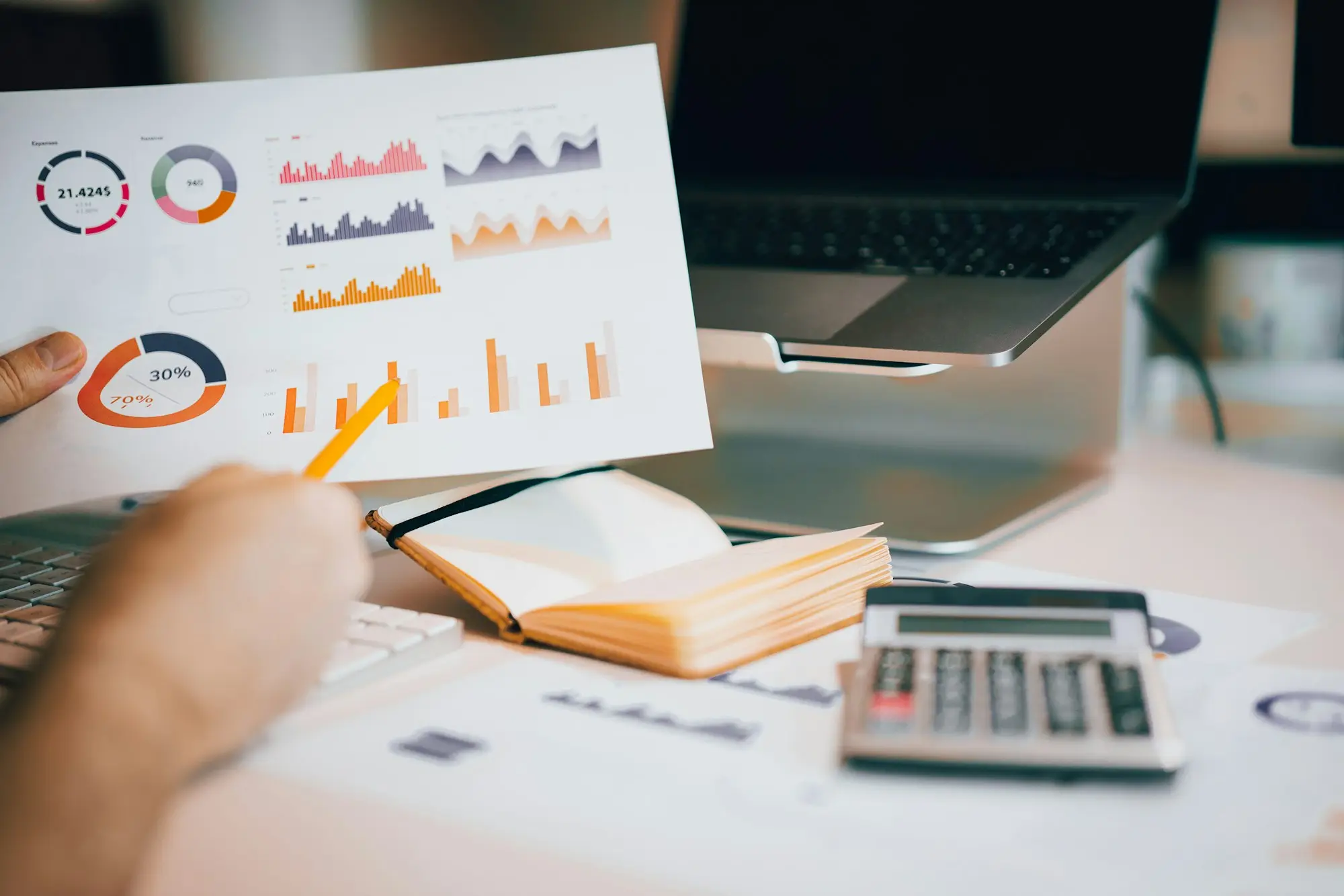 Bookkeeper reviewing printed charts and figures at the desk